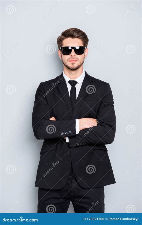 Portrait Of Bodyguard In Black Suit And Glasses With Crossed Hands