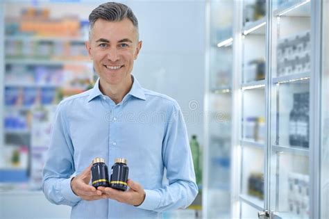 Short Haired Mature Man With Jars Of Supplements At The Drugstore Stock