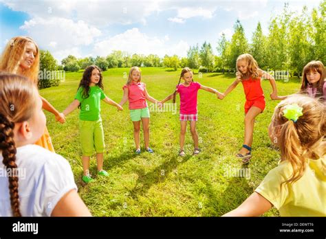 Many Happy Girls Friends Play Roundelay And Stand In Circle In The Park