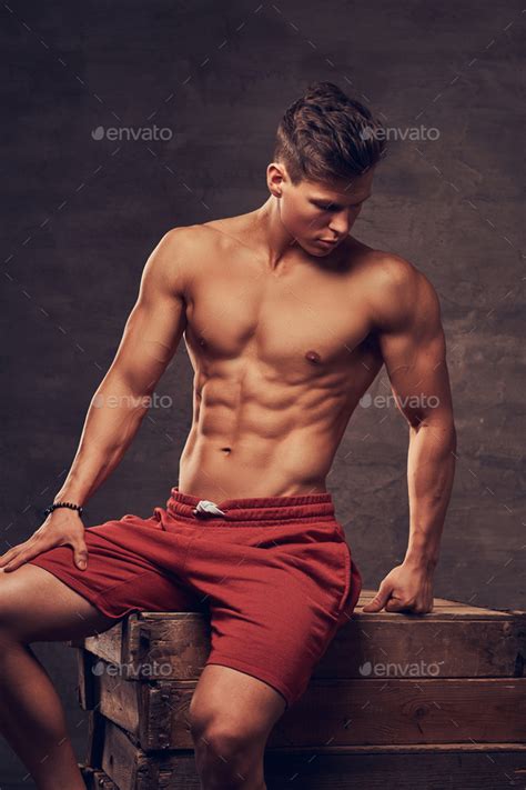 Sexy Shirtless Young Man Model In Red Shorts Posing At A Studio While