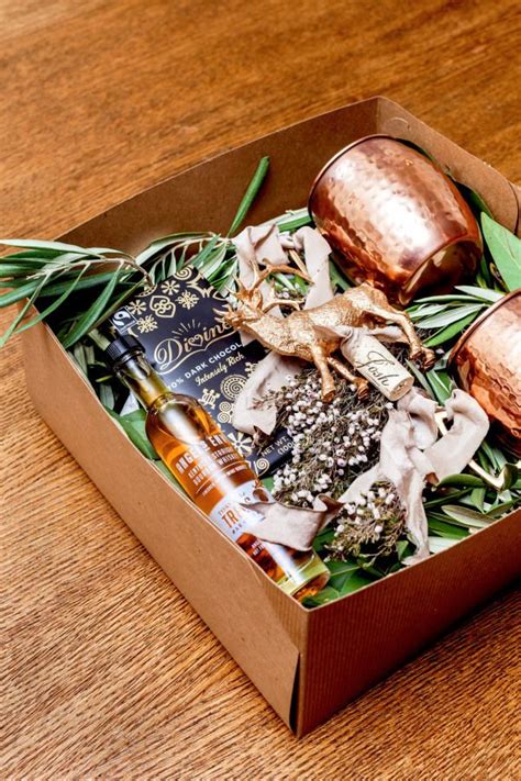 An Open Box Filled With Assorted Items On Top Of A Wooden Table Next To A Bottle