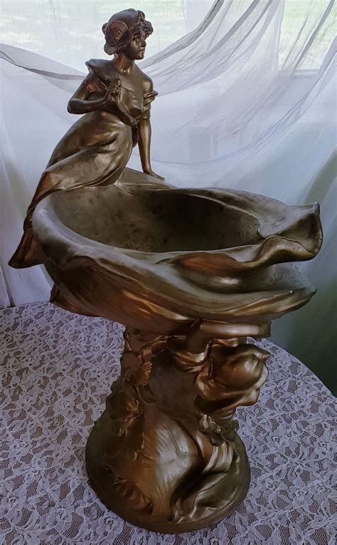 A Bronze Statue Sitting On Top Of A Table