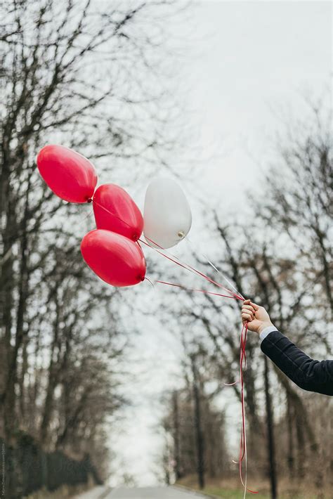 Hand Holding Heart Shaped Balloons Del Colaborador De Stocksy