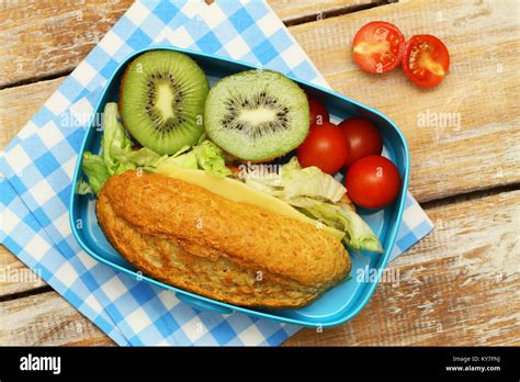 Healthy Packed Lunch Containing Wholegrain Cheese Sandwich Kiwi Fruit And Cherry Tomatoes Stock