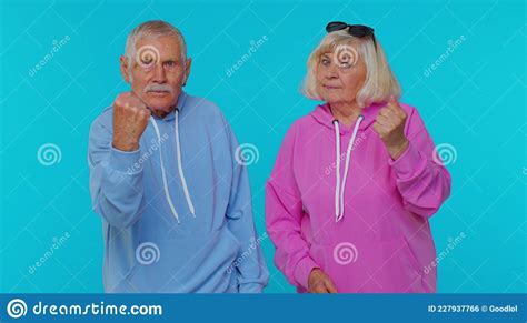 Aggressive Senior Woman Granny With Man Grandfather Trying To Fight At