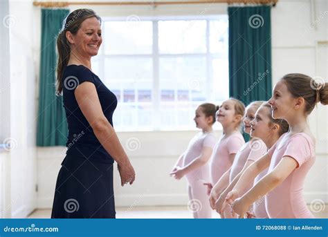 Group Of Young Girls With Teacher In Ballet Dancing Class Stock Photo