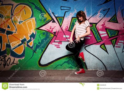 Stylish Girl In A Dance Pose Against Graffiti Wall Stock