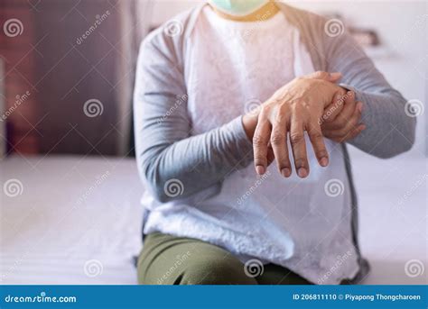 Mature Woman Suffering With Parkinson`s Disease Symptoms On Hand Stock