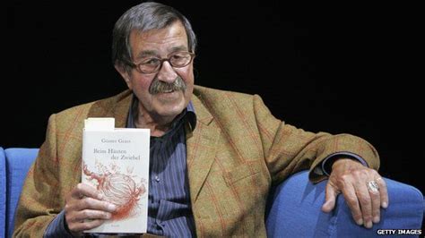 An Older Man Sitting On A Blue Couch Holding A Book