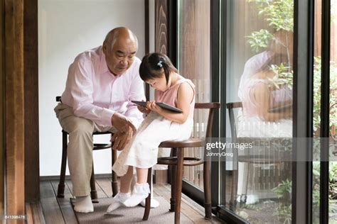 Senior Japanese Man With Granddaughter Using Digital Tablet High Res
