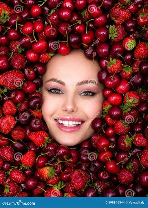Молодая девушка с ярким макияжем и с улыбкой на фоне ягоды Привлекательная женщина с белыми