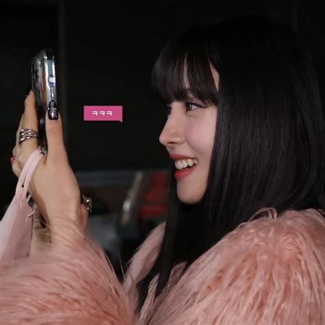A Woman Holding Up A Cell Phone To Take A Selfie With Her Pink Fur Coat