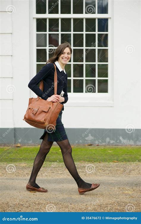 Portrait Of A Female Student Walking Outdoors With Bag Stock