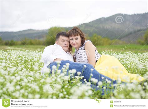 Lovers Meet Men And Women On A Beautiful Flower Field Stock Photo