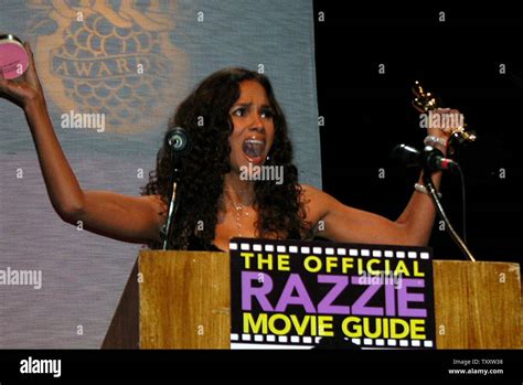 Halle Berry Holds Her Razzie Award For Worst Actress Of 2004 In One