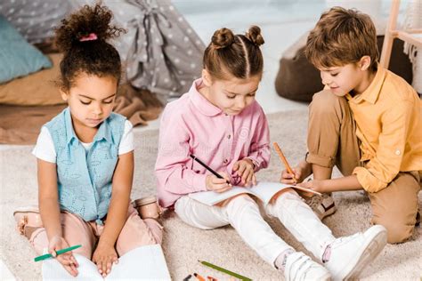 Adorable Multiethnic Children Sitting On Carpet And Stock Image Image
