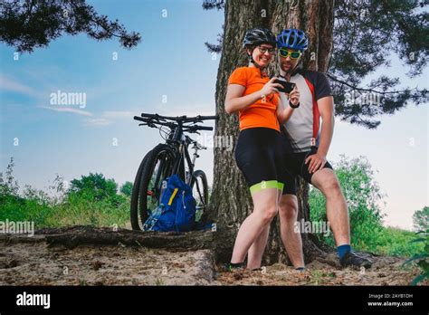 happy couple searching on map in smartphone destination man and woman in helmets traveling