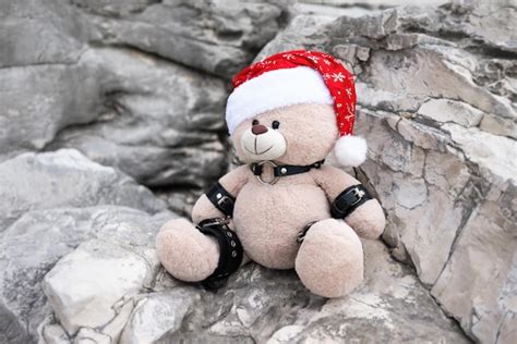 premium photo bdsm accessories on a plush christmas bear in a santa claus hat on the