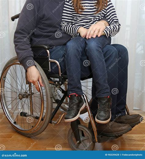 Disabled Parent In A Wheelchair With His Little Daughter Stock Photo