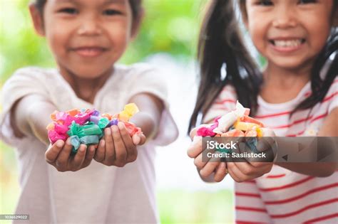 Two Asian Child Girls Holding Sweet Candies In Thier Hands And Share To