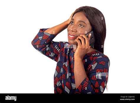 Happy African Mature Woman Standing Sideways Talking On Mobile Phone And Touching Her Long Black