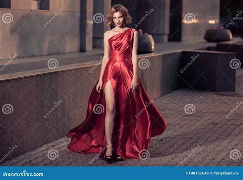 Young Beautiful Woman In Fluttering Red Dress City Background Stock