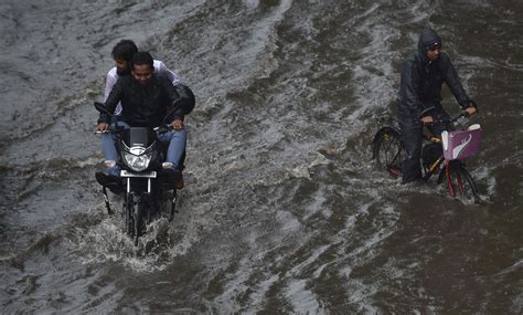 indian commuters make their way through a waterlogged street after heavy rain in mumbai first