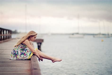 Girl Sitting On A Dock On A Cloudy Day Porangela Lumsden