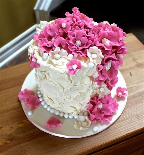 rustic buttercream cake with cascading flowers bouquet pink and white and pearls cake butter