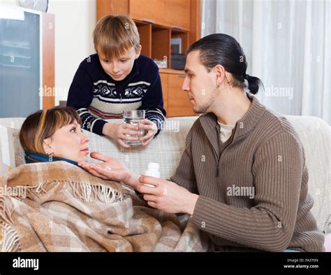 Man Caring For Sick Wife And Mother Son Helps Him At Home Stock Photo
