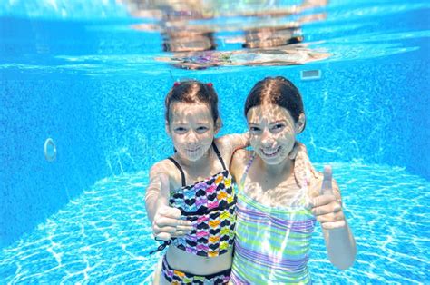 Children Swim In Pool Underwater Happy Active Girls Have Fun Under