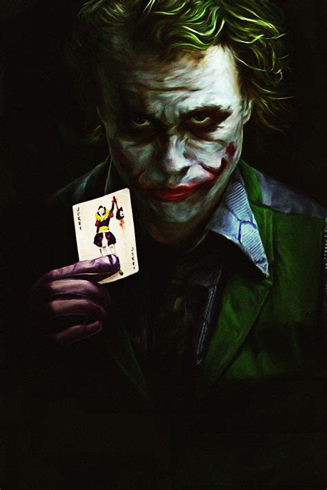 The Joker Holding Up A Playing Card In His Hand