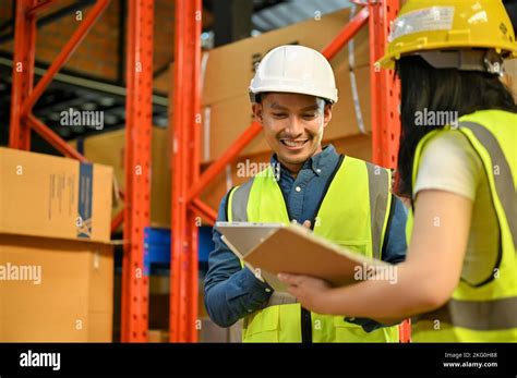professional millennial asian male warehouse supervisor working with female worker in the