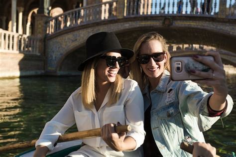 free photo women taking selfie while riding boat