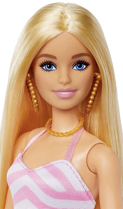 A Barbie Doll With Blonde Hair Wearing A Pink And White Striped Dress Gold Hoop Earrings