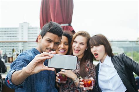 Cool Young Indian Man Taking Smartphone Selfie With Three Tipsy Women At Rooftop Bar By