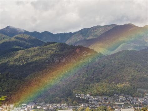 Beautiful Rainbow Over The Forest Mountains And A Town Stock Image