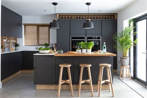 The dark paint allows you to have a deep rich tone while staying with a neutral color palette. Stunning modern handleless kitchen mixing dark grey and wood effect cabinets. Pictured H L ...