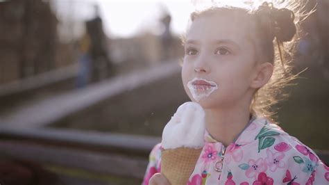 Child Enjoys Ice Cream On Park Bench Portrait Stock Footage Sbv