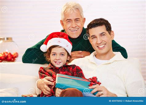Child Celebrating Christmas With Father And Grandfather Stock Photo