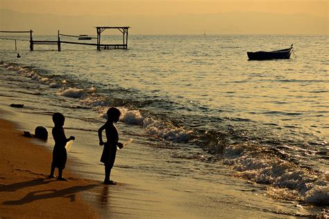 Two Kids On The Shore Of Lake Malawi At Sunset In The Village Of Chembe