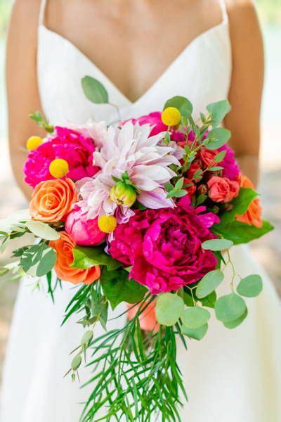 A Bridal Holding A Bouquet Of Flowers And Greenery