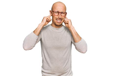 Bald Man With Beard Wearing Casual Clothes And Glasses Covering Ears