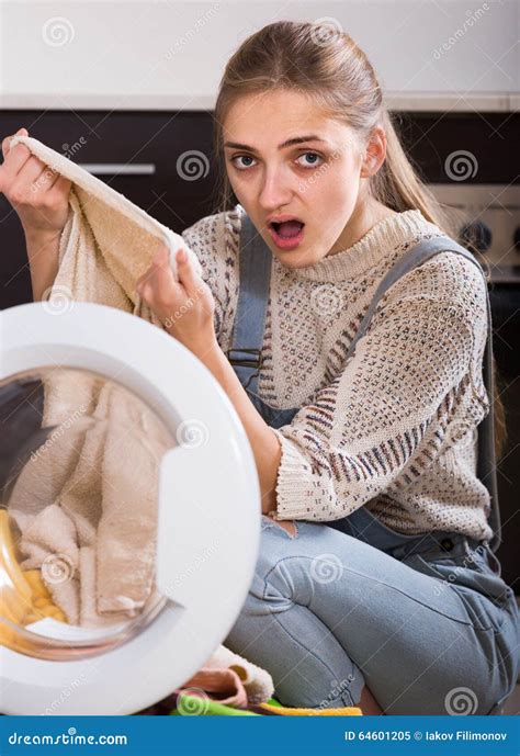 Portrait Of Housewife Taking Dirty Clothes Out Washer Stock Image