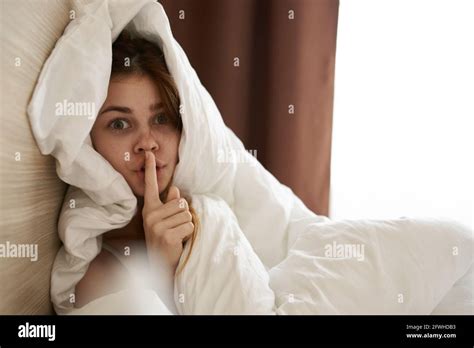 Cute Woman Tied Up Under Blanket In Bed In The Morning Near Window