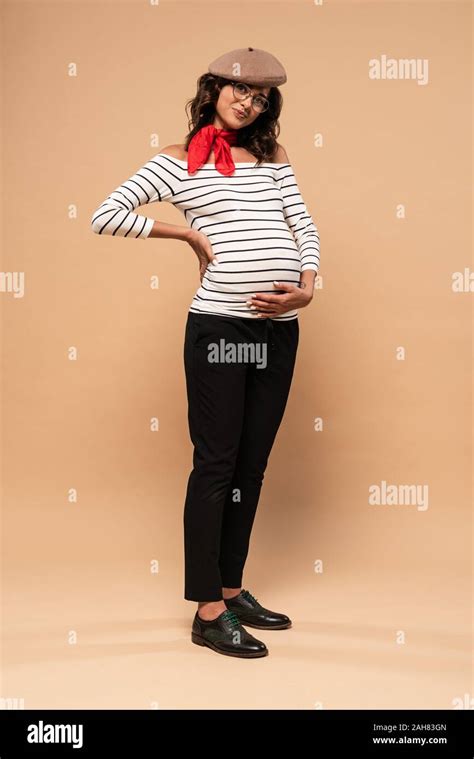 Pregnant French Woman In Beret Looking At Camera On Beige Background Stock Photo Alamy
