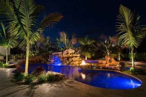 Even smaller backyards can accommodate lagoon pools thanks to their freeform shapes. Natural lagoon pool sundeck wading area at night with fire ...