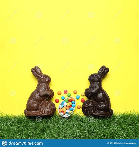 Chocolate Easter Bunnies Halved Egg And Candies With Green Grass On