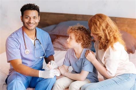 Positive Delighted Medical Worker Treating Injured Hand Stock Photo