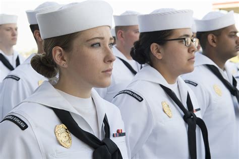 For simplicity in this article, officers refers to both commissioned officers and warrant officers. Sailors stand in formation for a dress white uniform inspe ...